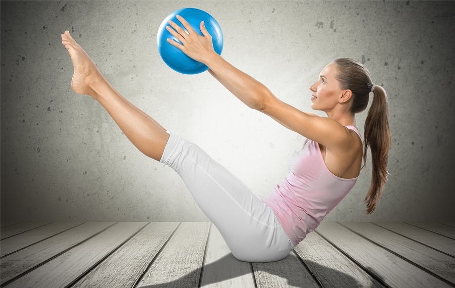 Femme en posture pilates avec ballon